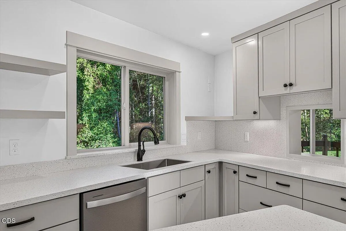 The finished kitchen sink and counter beneath the corner windows